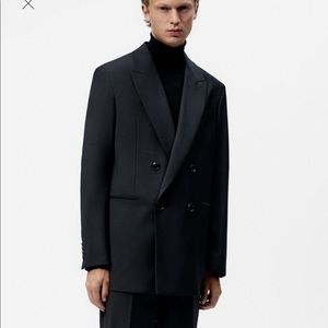 Jacket with notched lapel collar. Long sleeves with buttoned cuffs. Welt pockets